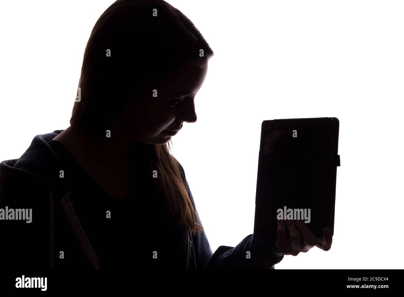 Silhouette eines Mädchens in der Kapuze mit einem Tablet, ein Symbol der Anonymität im Internet - isolieren Stockfoto