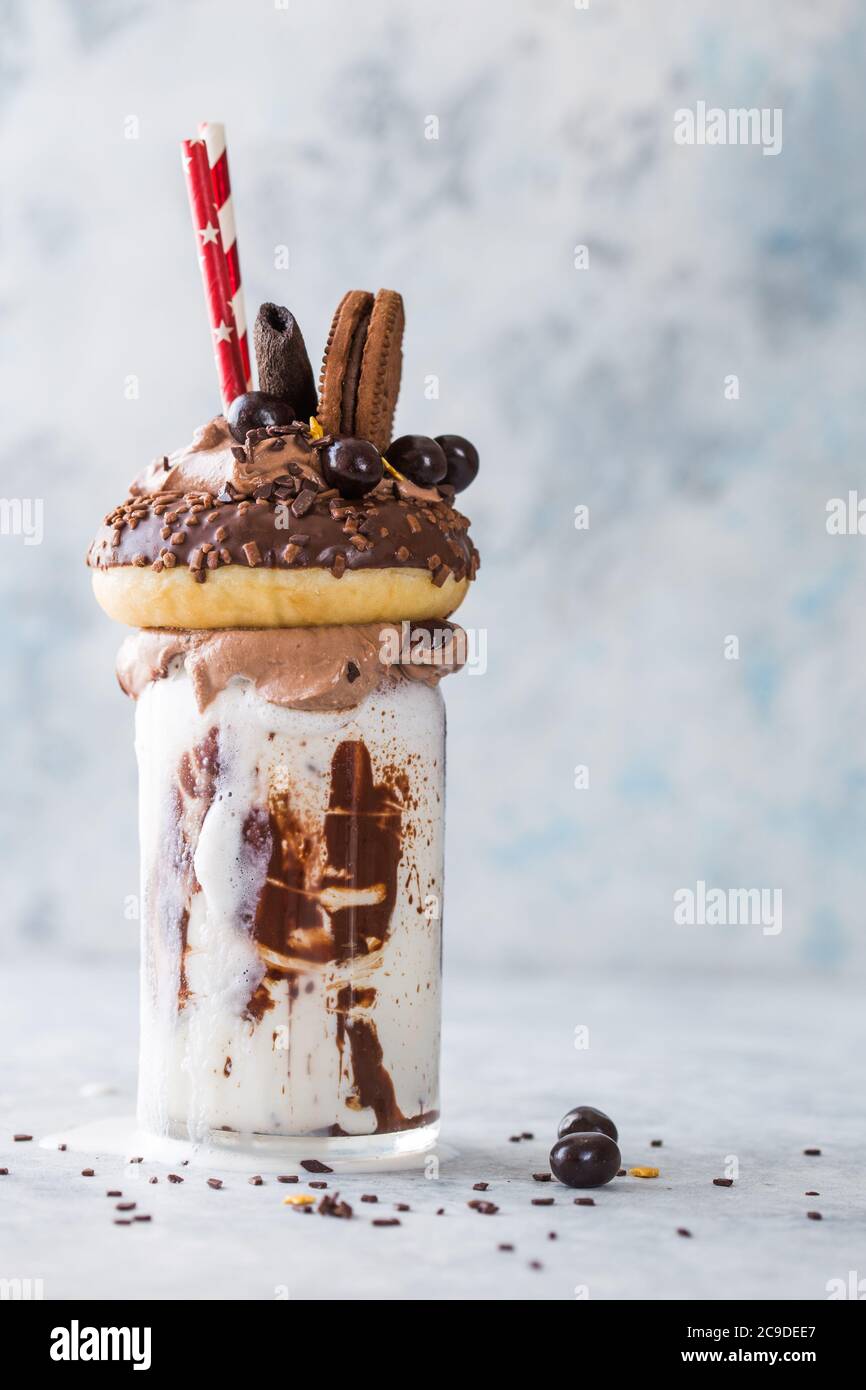 Schokoladenverwöhnendes Frosting exreme Milchshake mit Donut und Süßigkeiten. Crazy Freakshake Food Trend. Speicherplatz kopieren Stockfoto