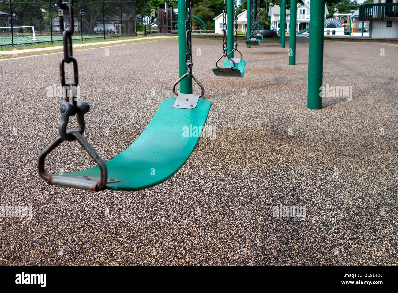 Eine Reihe von Schlingen schwingt auf einem Kinderparkplatz mit weichem gummiartigen Boden Stockfoto
