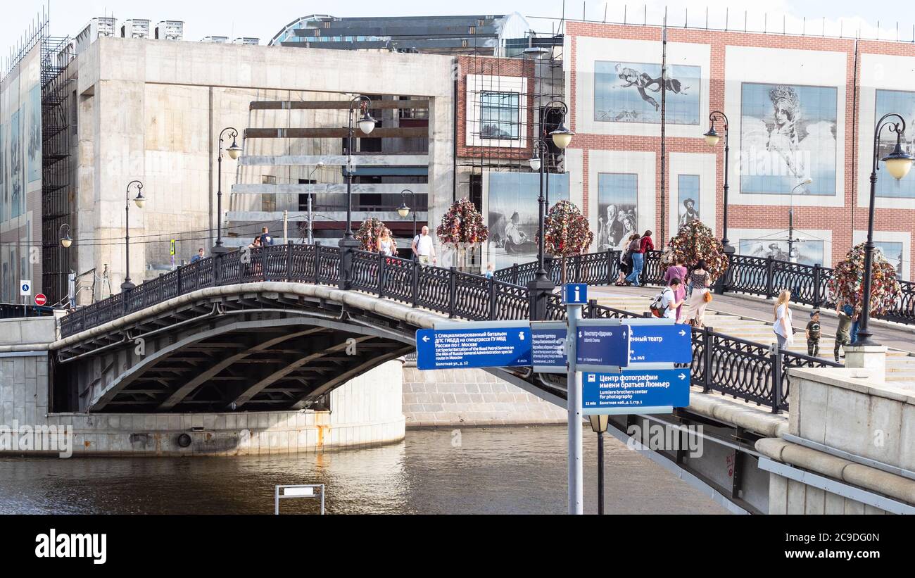 MOSKAU, RUSSLAND - 25. JULI 2020: Menschen auf der Luschkow-Brücke (Tretjakowski-Brücke) in der Nähe der Renovierung Gebäude der Tretjakow-Galerie in Moskau Stadt im Sommer Stockfoto