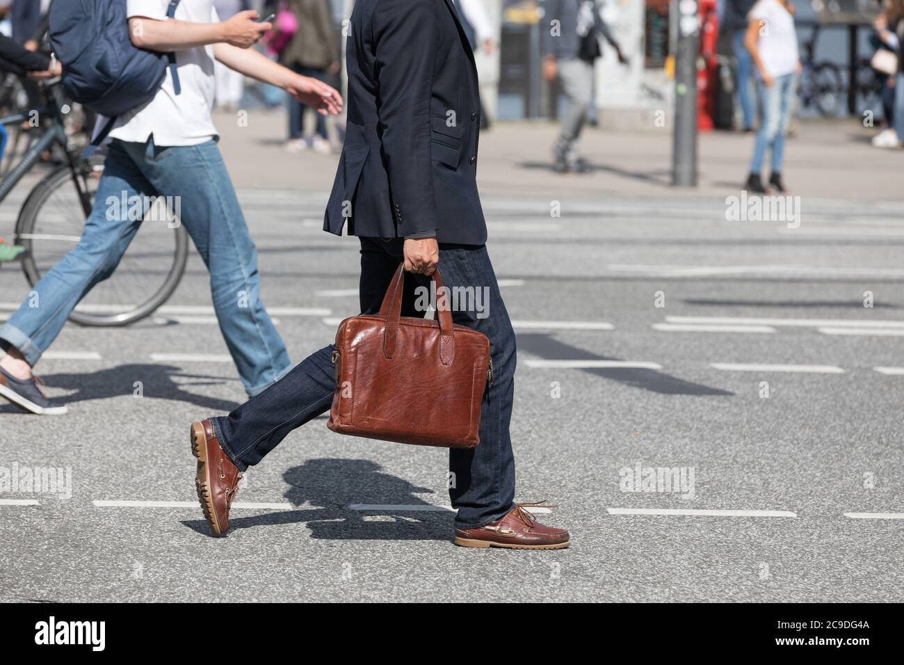 Geschäftsmann mit brauner Ledertasche auf der Straße Stockfoto