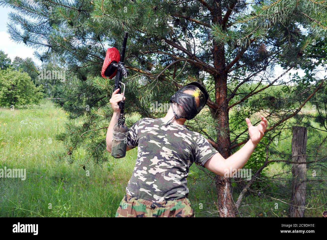 Paintball Spieler in Tarnuniform und Schutzmaske wurde vom Feind im Kopf getötet. Stockfoto