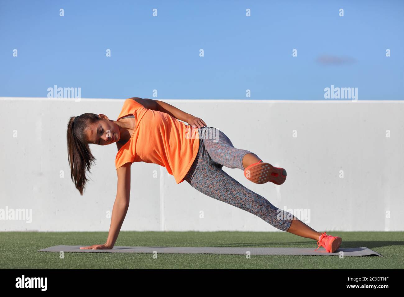 Side Plank Bein heben Fitness Frau Training Körper Kern Planken Übung. Training im Freien Fitnessraum oder Garten asiatische Mädchen Ausübung schrägen abs Stockfoto
