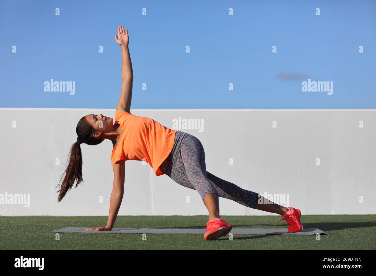 Yoga Pose Variation Fitness-Mädchen tun die gefallenen Dreieck mit Bein assited. Asiatische Frau tun Seitenplanke mit seitlichen Bein heben. Planken Übung Stockfoto