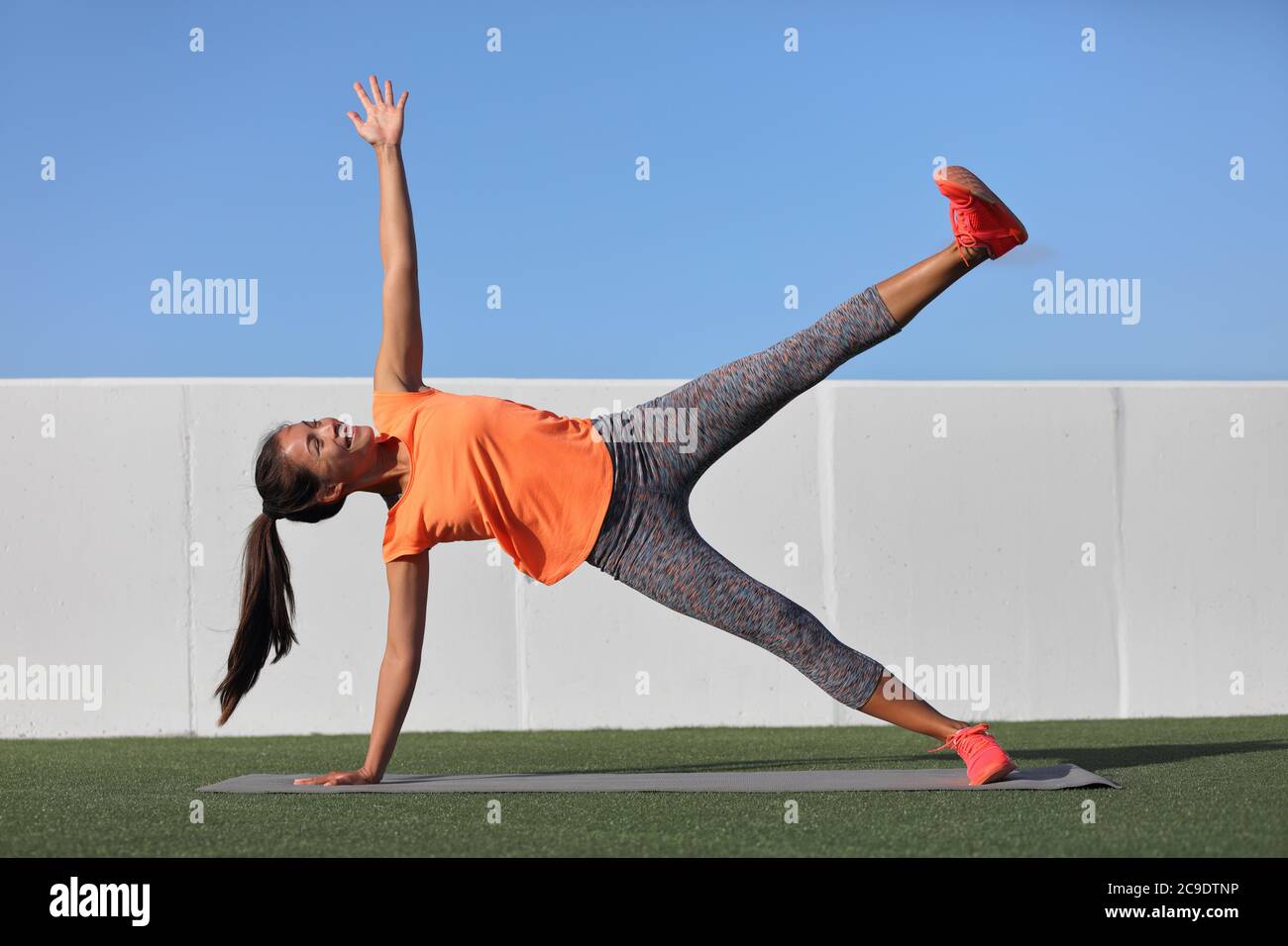 Sternenseite Plank. Yoga Frau planken tun Bein heben Kernübung in Fitness-Gym-Klasse. Asiatische Mädchen Training Seite Plank Bein heben Körperkern in Yoga Stockfoto
