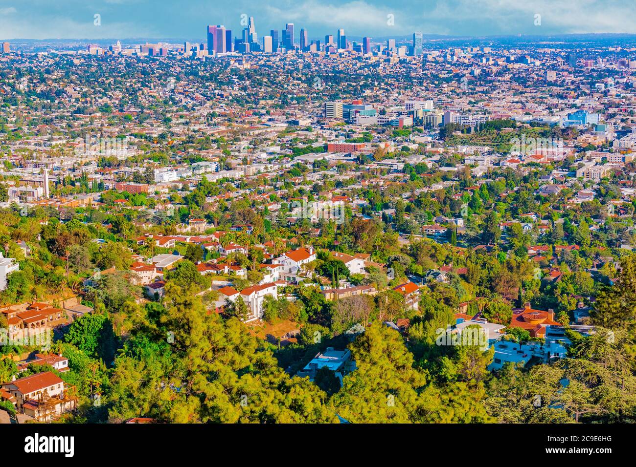 Ein Blick auf den Hügel der städtischen Zersiedelung von Los Angeles zeigt Wolkenkratzer in der Ferne und Häuser auf Hügeln im Vordergrund gebaut. Stockfoto
