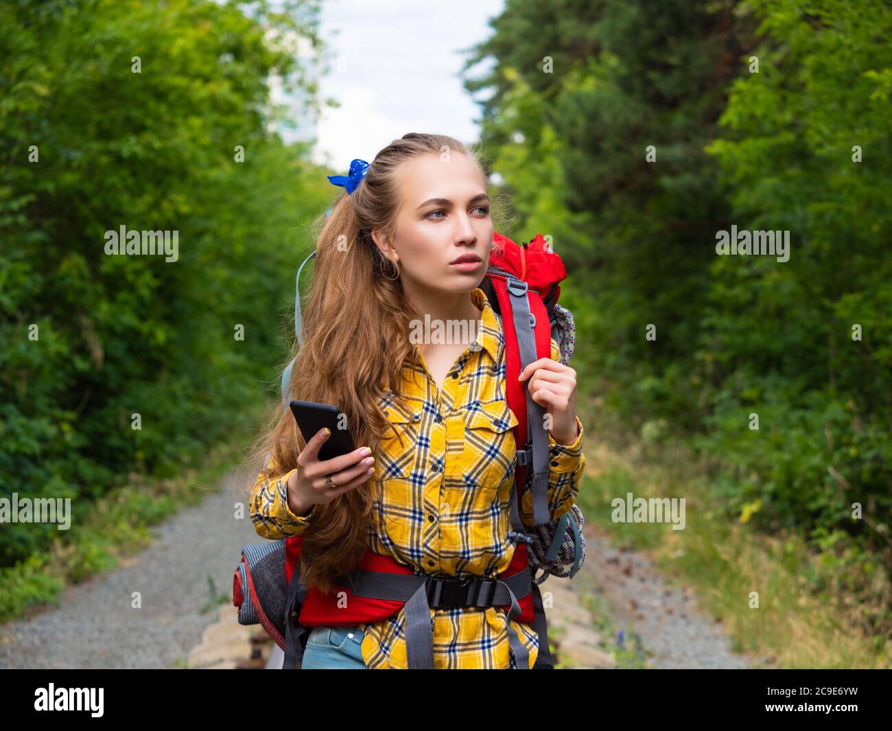 Porträt einer Wanderfrau im Wald verloren. Sie verwendet eine mobile GPS-Karte. Stockfoto