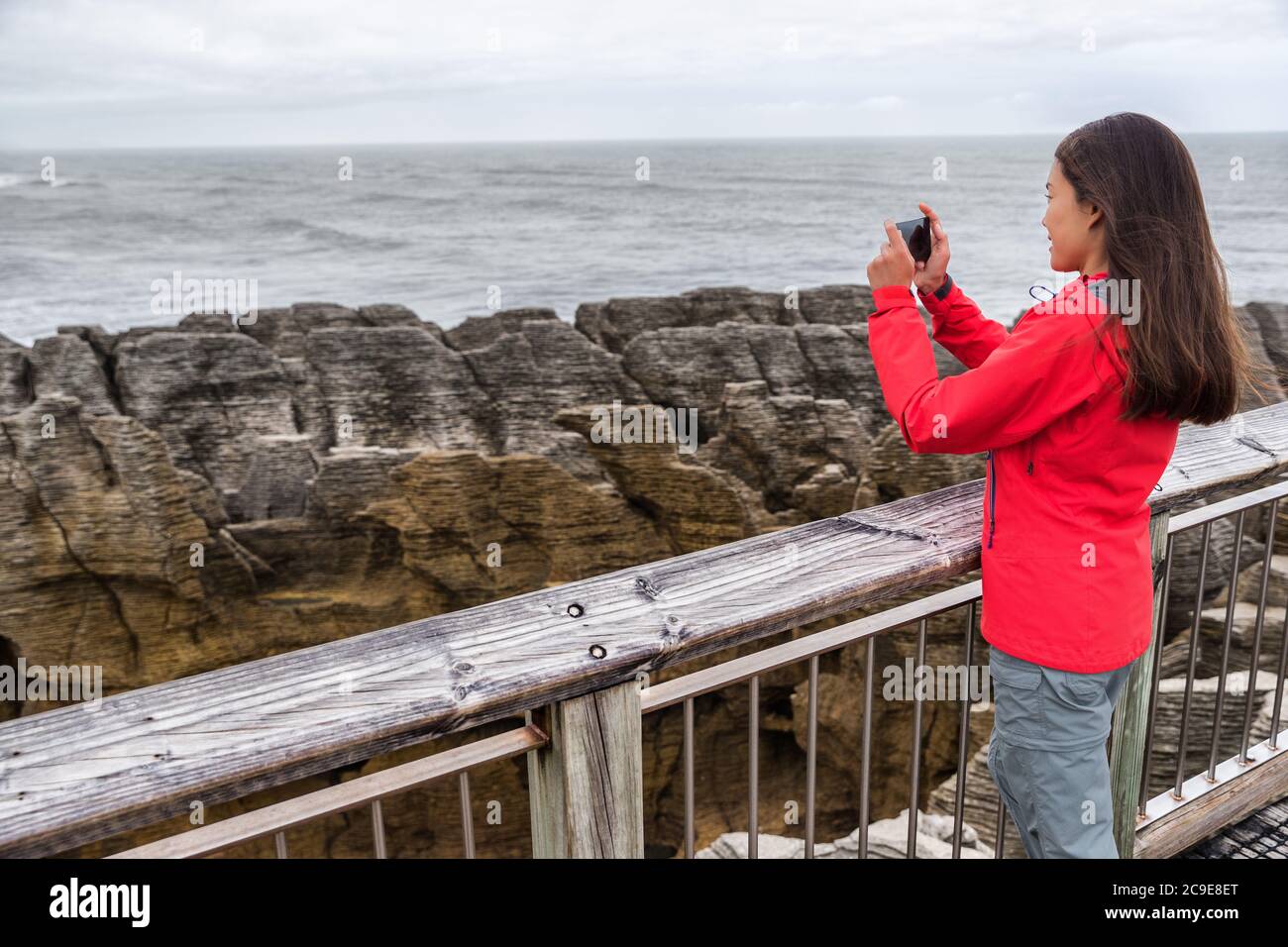 Neuseeland Reise-Tourist-Mädchen, das Smartphone-Bilder mit Handy-App auf Punakaiki Pancake Rocks. Frau im Paparoa National Park, Westküste Stockfoto