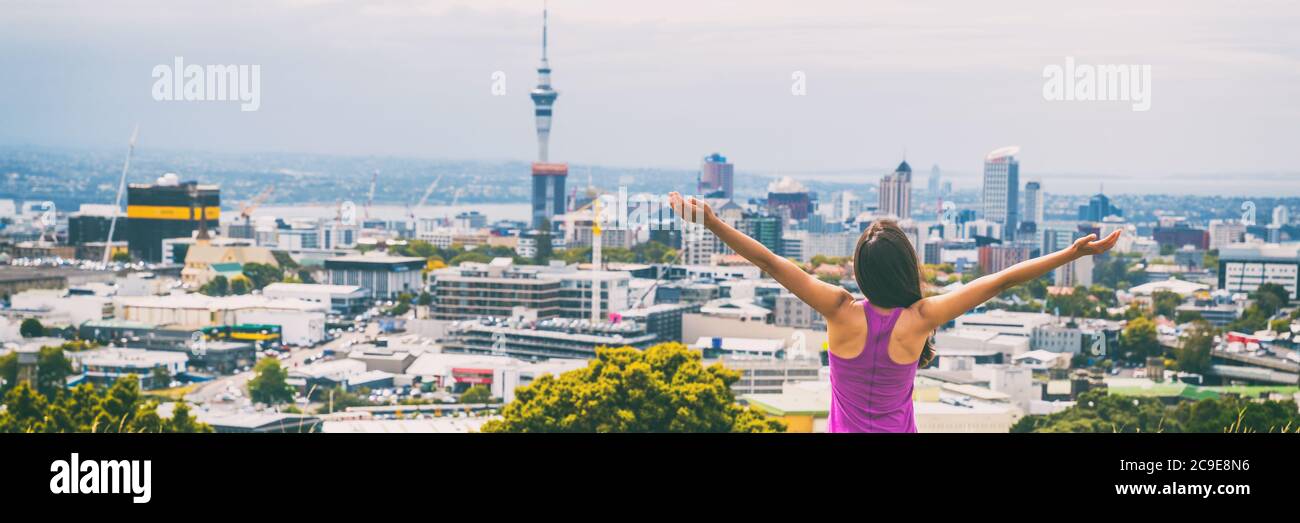 Blick auf die Skyline von Auckland vom Mount Eden Banner. Sky Tower, Neuseeland. Glückliche Frau mit Armen in Freiheit und Glück auf dem Gipfel des Mt Eden Urban Stockfoto