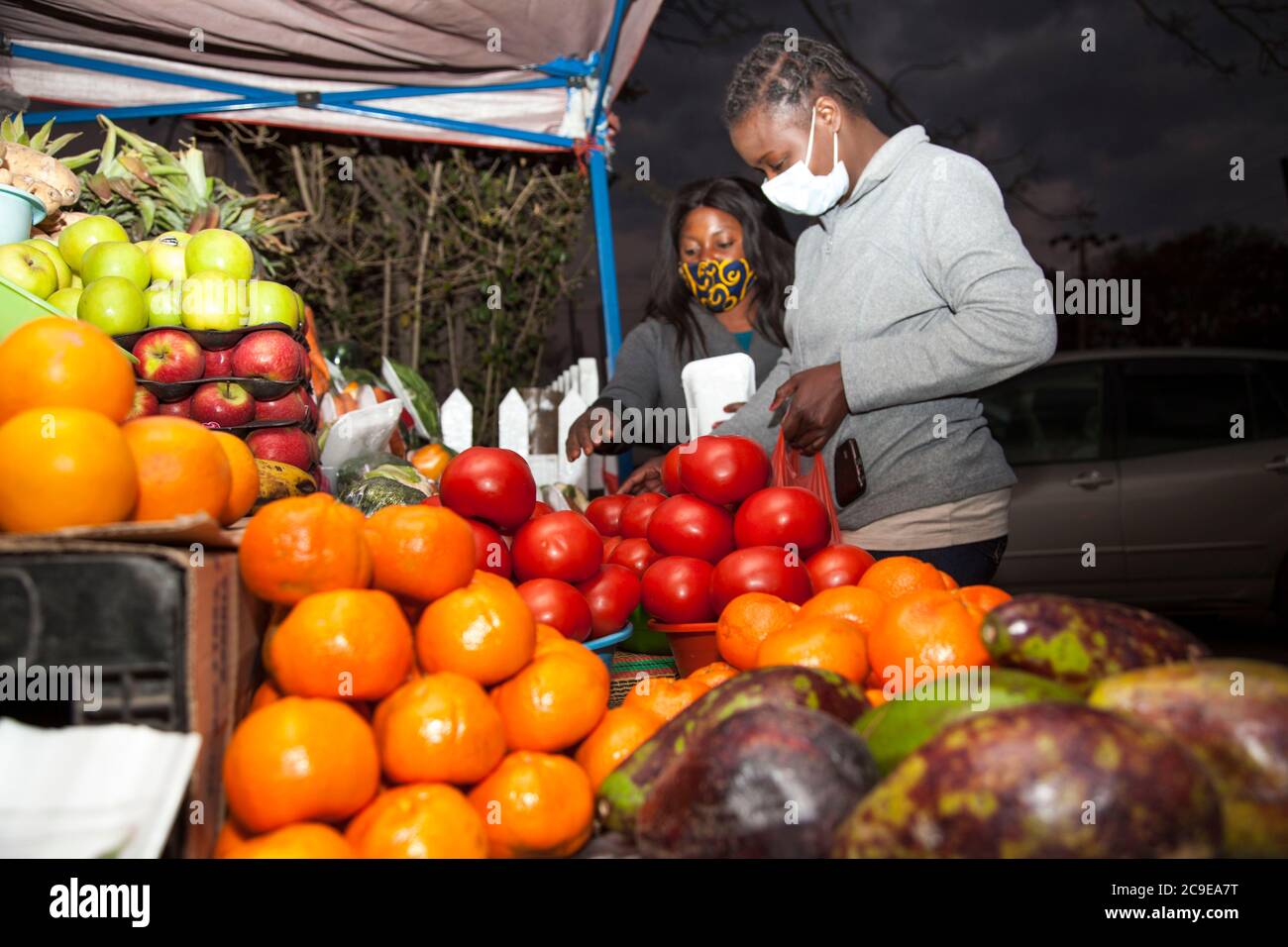 Lusaka, Sambia. Juli 2020. Ein Händler hilft einem Kunden, Gemüse zu verpacken, das sie gerade im Foxdale Mall Thursday Market in Lusaka, Hauptstadt von Sambia, am 30. Juli 2020 gekauft hat. Quelle: Martin Mbangweta/Xinhua/Alamy Live News Stockfoto