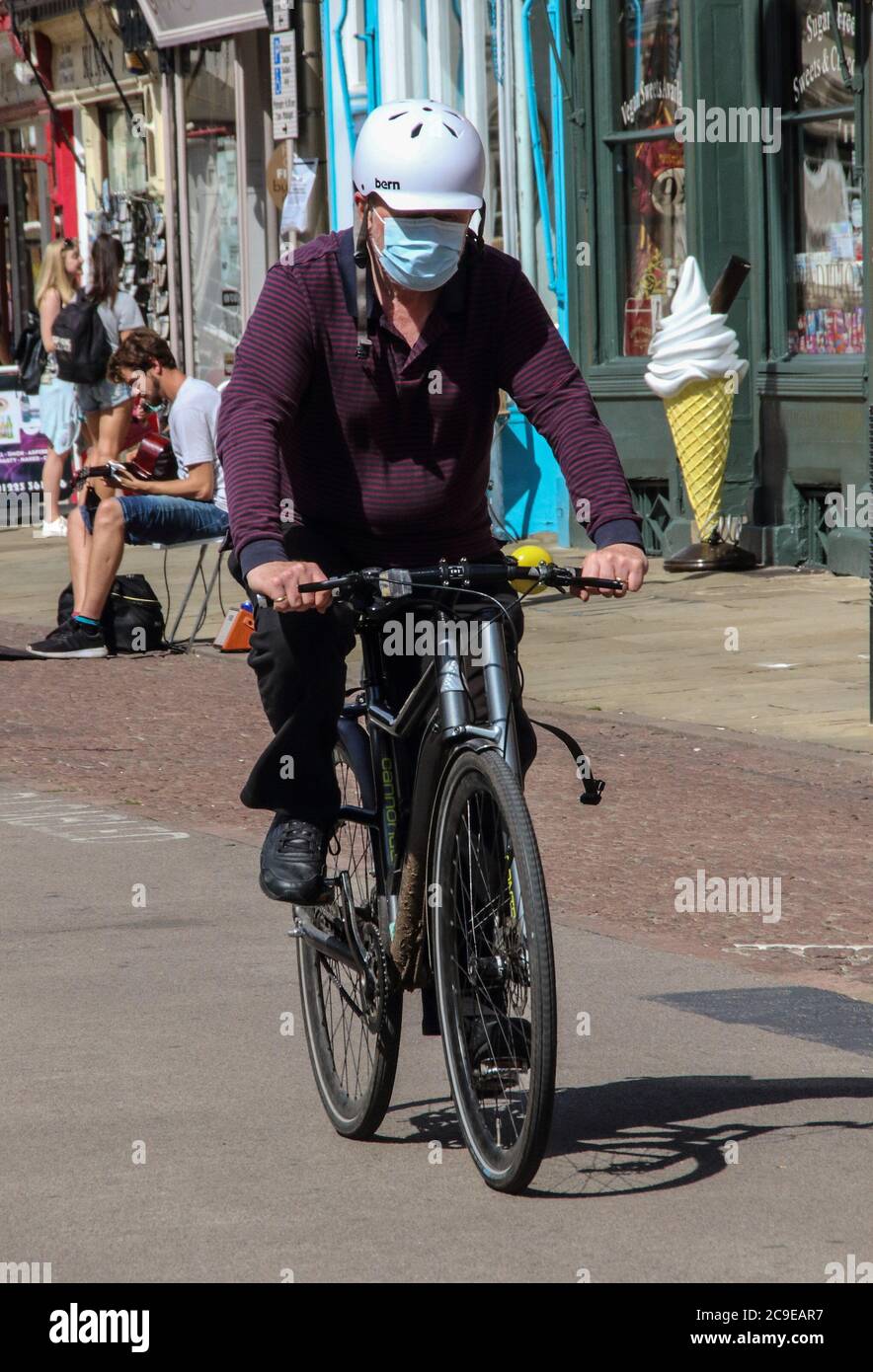 Cambridge, Großbritannien. Juli 2020. Ein Mann, der eine Gesichtsmaske als vorbeugende Maßnahme trägt, fährt mit dem Fahrrad auf der Straße. Die Menschen tragen eine Vielzahl von Gesichtsmasken im Freien in Cambridge, obwohl sie im Moment in Großbritannien nur auf öffentlichen Verkehrsmitteln und in Geschäften und öffentlichen Räumen vorgeschrieben sind. Kredit: SOPA Images Limited/Alamy Live Nachrichten Stockfoto