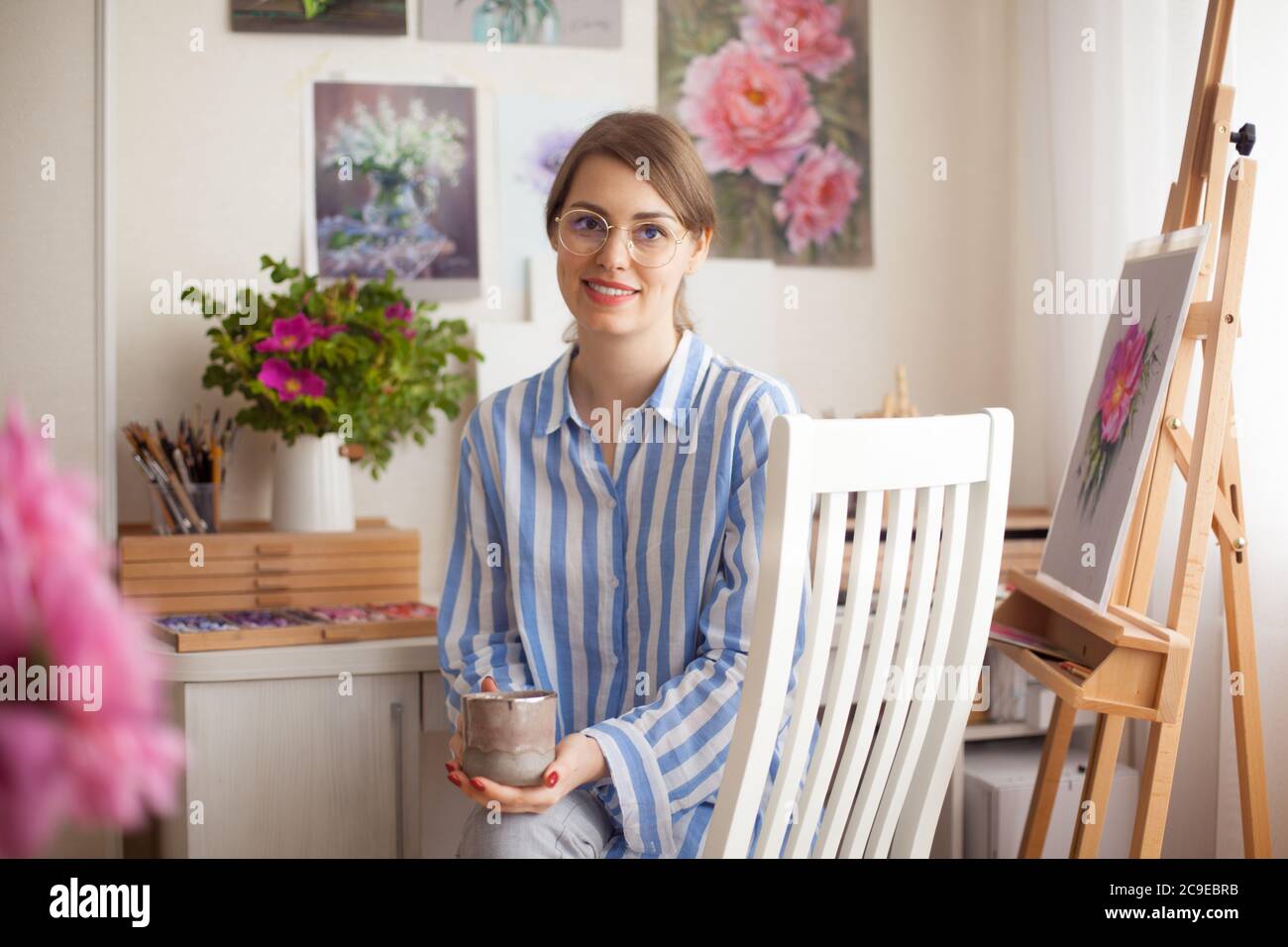 Kaukasische schöne lächelnde Mädchen Künstler mit Gläsern Farben im Studio zu Hause Stockfoto
