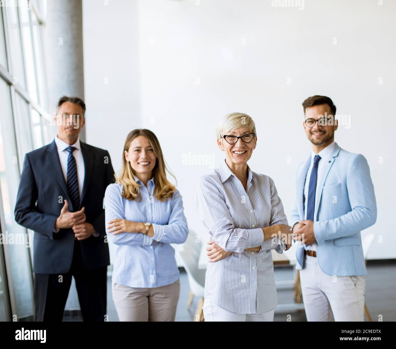Gruppe von Geschäftsleuten, die zusammen im Büro mit ihrer reifen weiblichen Geschäftsführerin stehen Stockfoto