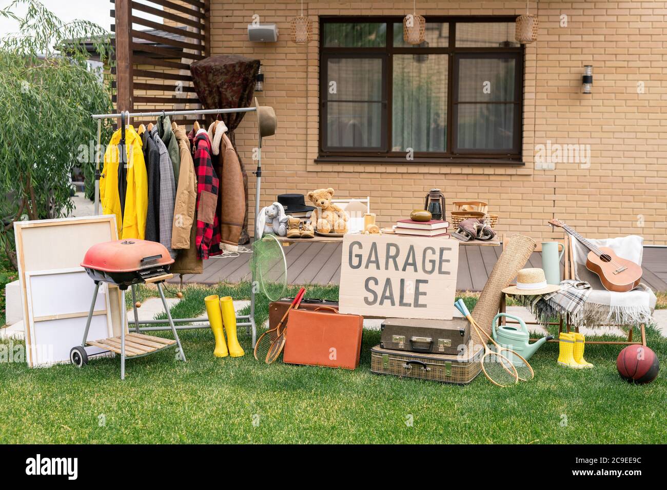 Garagenverkauf im Hinterhof: Verschiedene Spielzeuge, Haushaltsgegenstände und Kleidung zum Verkauf Stockfoto