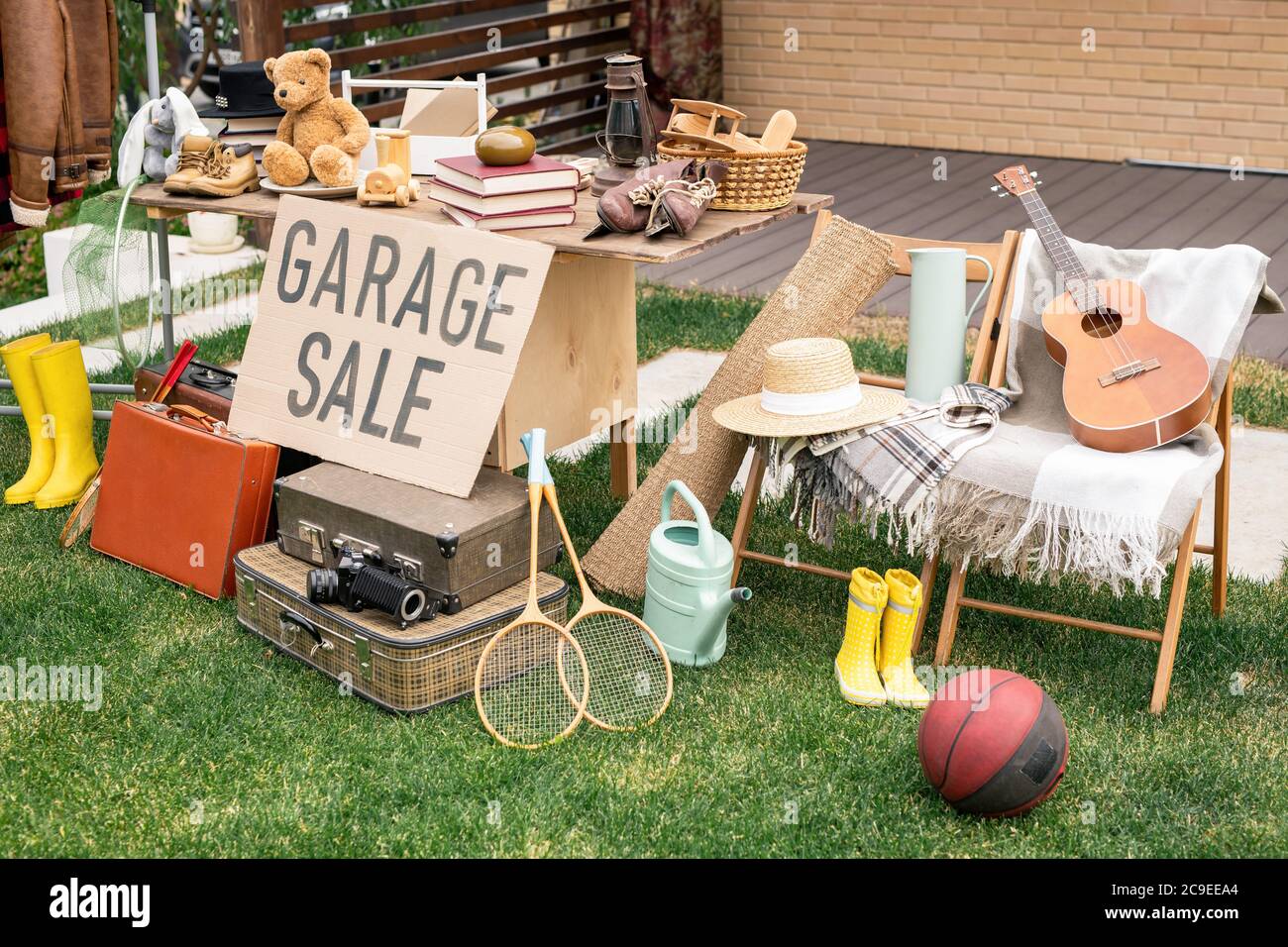 Verschiedene Dinge auf Tisch und Stühlen im Hinterhof platziert, Garage Verkaufskonzept Stockfoto
