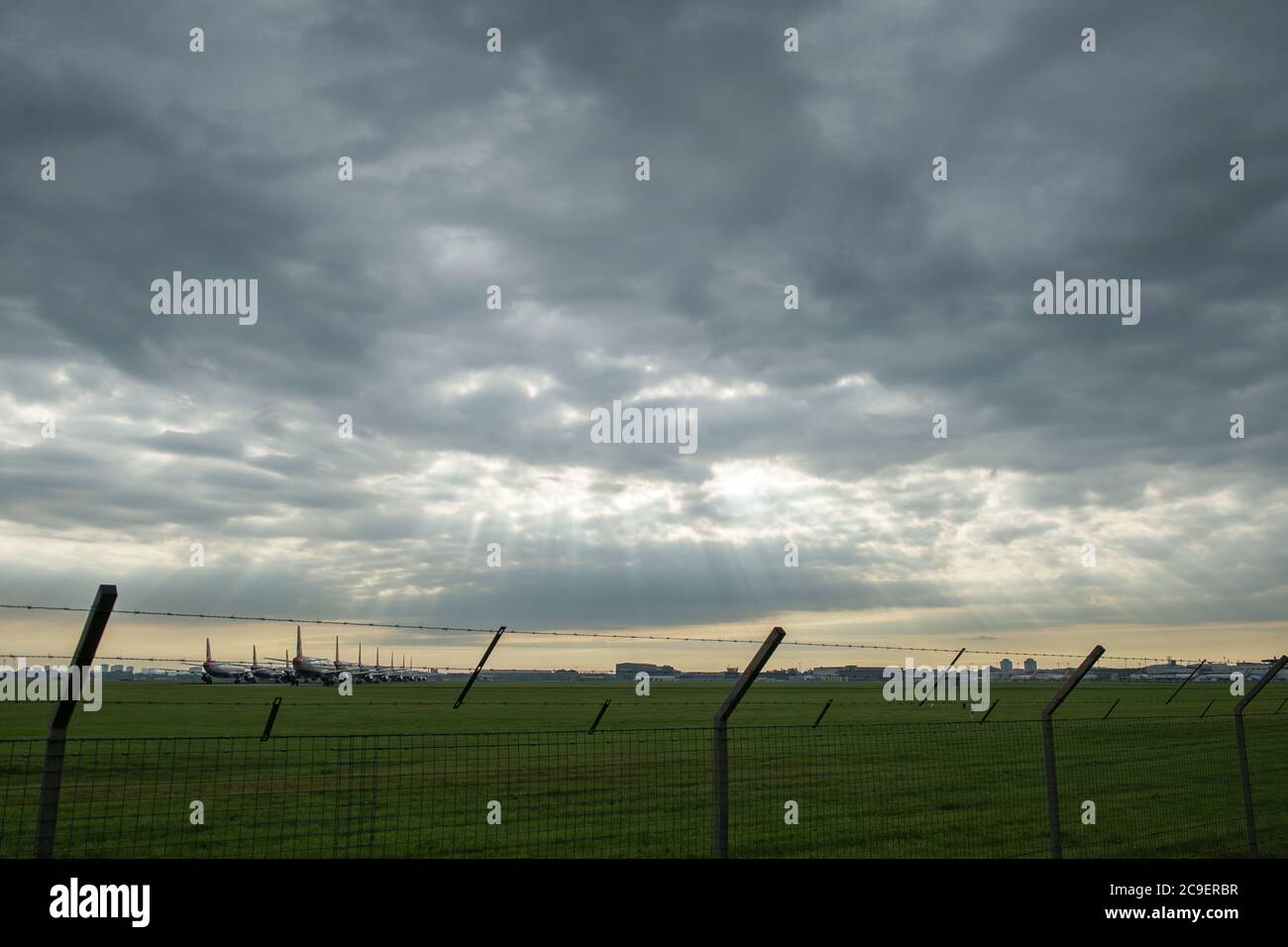 Glasgow, Schottland, Großbritannien. Juli 2020. Im Bild: Sonnenstrahlen durchbrechen die Wolken, die auf die am Flughafen Glasgow geerdeten Airbus-Flugzeuge der A319-, A320- und A321-Varianten von British Airways (BA) scheinen. Seit die Coronavirus-Pandemie (COVID-19) Großbritannien heimgesucht hat, hat British Airways ein Viertel seiner Mitarbeiter entbändet und seine gesamte Flotte von Boeing 747-Flugzeugen in den Ruhestand gesetzt, um Kosten zu senken. Quelle: Colin Fisher/Alamy Live News Stockfoto