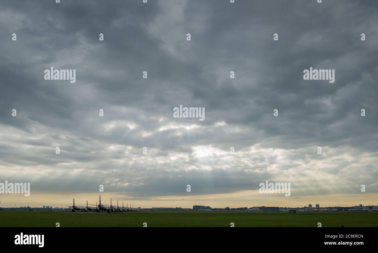 Glasgow, Schottland, Großbritannien. Juli 2020. Im Bild: Sonnenstrahlen durchbrechen die Wolken, die auf die am Flughafen Glasgow geerdeten Airbus-Flugzeuge der A319-, A320- und A321-Varianten von British Airways (BA) scheinen. Seit die Coronavirus-Pandemie (COVID-19) Großbritannien heimgesucht hat, hat British Airways ein Viertel seiner Mitarbeiter entbändet und seine gesamte Flotte von Boeing 747-Flugzeugen in den Ruhestand gesetzt, um Kosten zu senken. Quelle: Colin Fisher/Alamy Live News Stockfoto