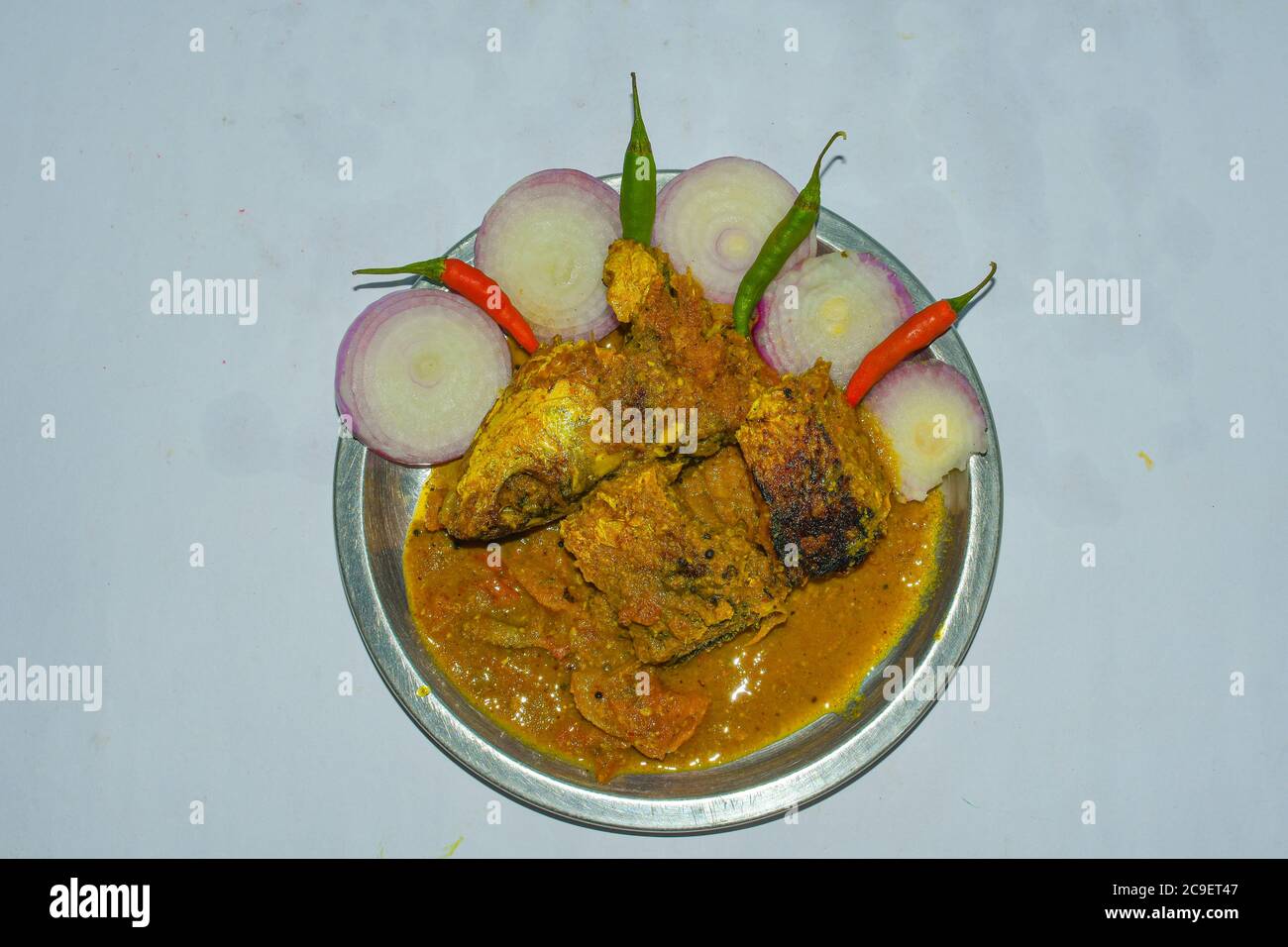 Fisch Gravey Curry auf EINEM Stahlteller mit Zwiebeln & grünen roten Chilis. Stockfoto
