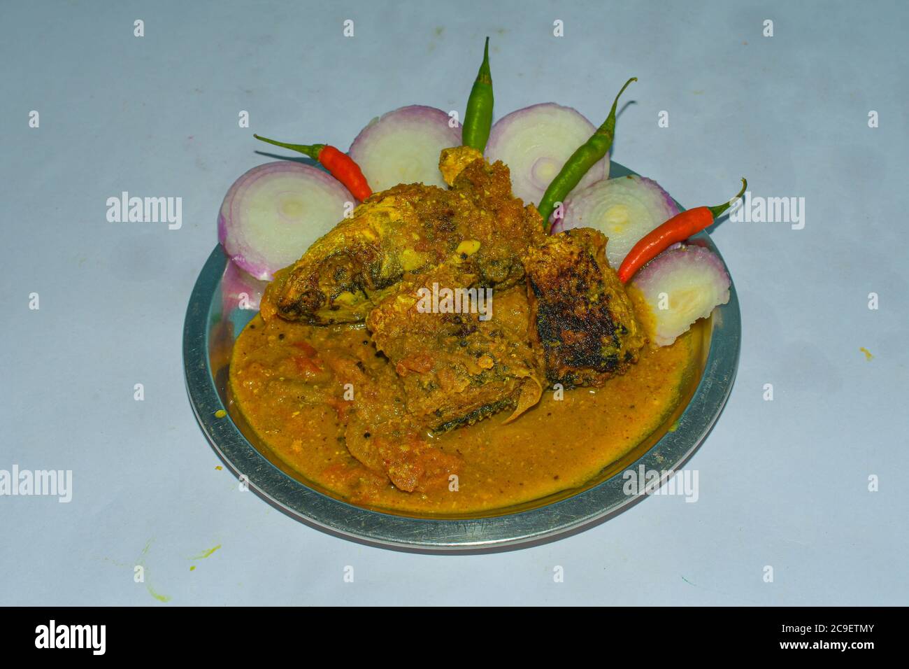 Fisch Gravey Curry auf EINEM Stahlteller mit Zwiebel & Chilis. Stockfoto