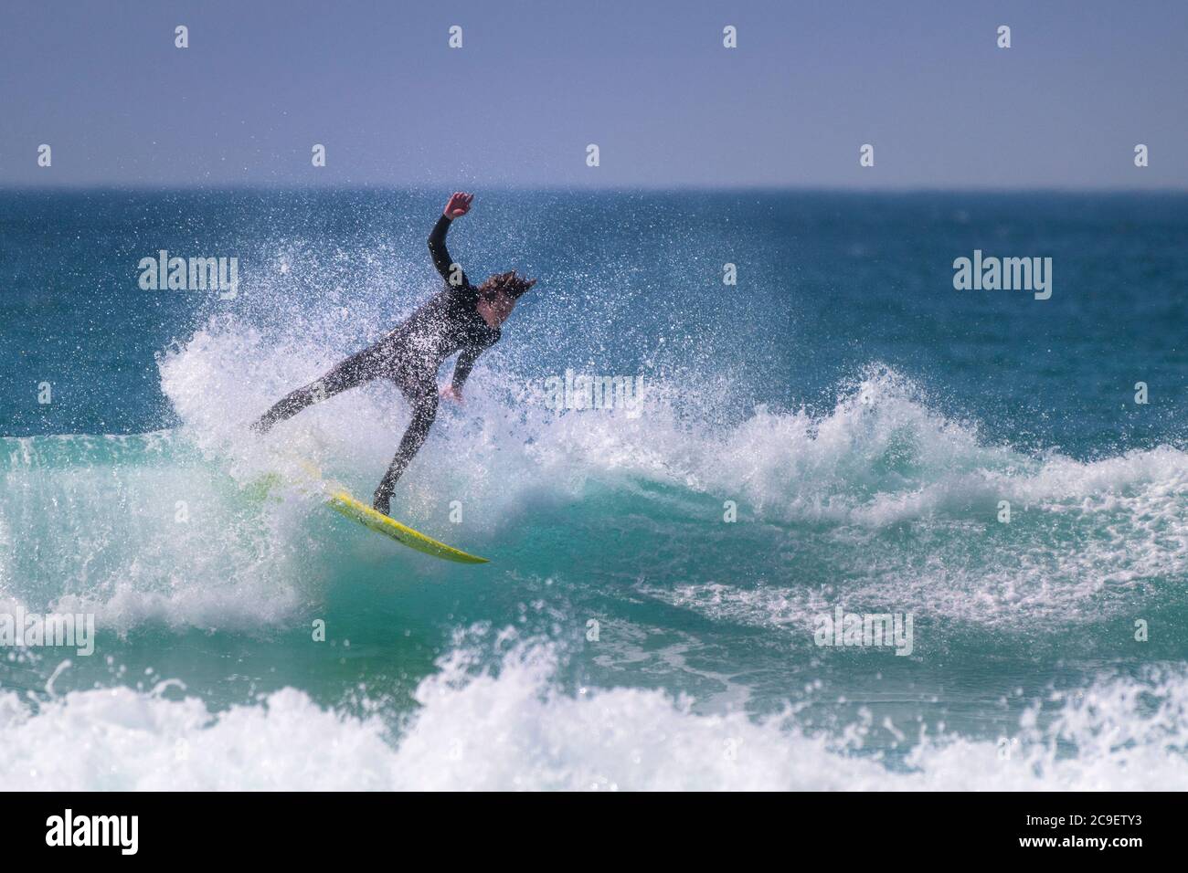 Wilde spektakuläre Action als Surfer reitet eine Welle am Fistral in Newquay in Cornwall. Stockfoto