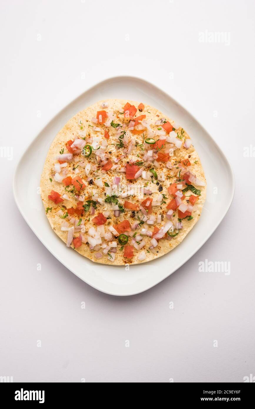 Masala Papad oder Papadum ist ein köstlicher indischer Snack, der aus gerösteten oder gebratenen Papaden mit einer würzigen Zwiebeltomate-Mischung garniert wird Stockfoto