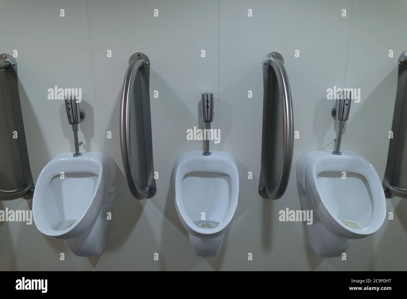 Drei keramische Urinale in der öffentlichen Toilette der Männer Stockfoto