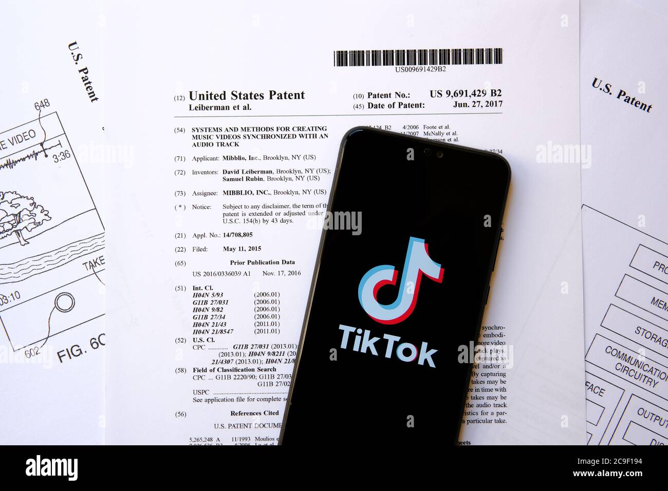 TikTok-Logo auf dem Smartphone auf einem echten US-Patent No.9691,429 platziert. Das Patent, für das TikTok von Rivalen Triller wegen Patentverletzung verklagt. Stockfoto