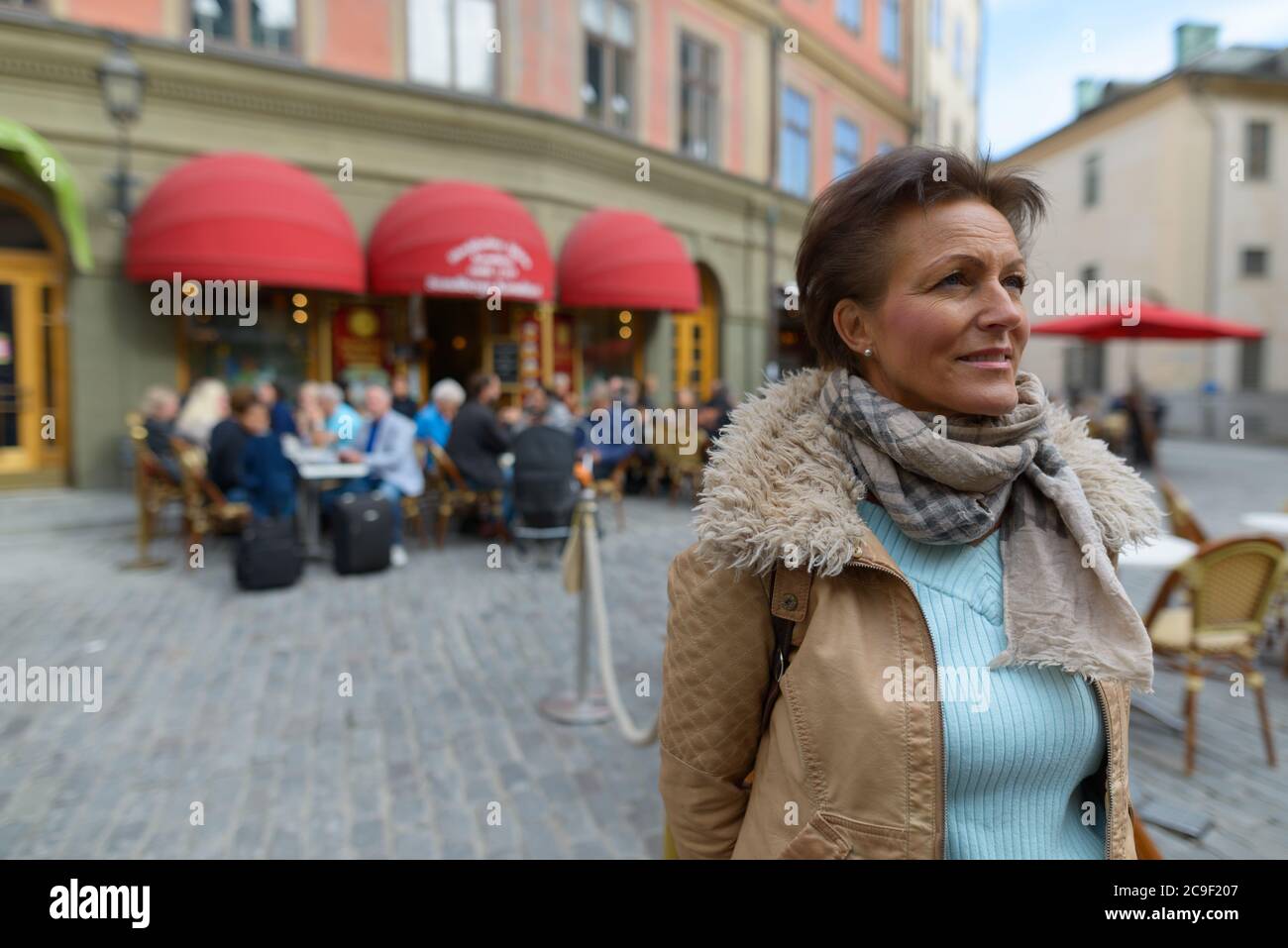 Reife schöne touristische Frau, die gegen Blick auf das Restaurant im Freien denken Stockfoto