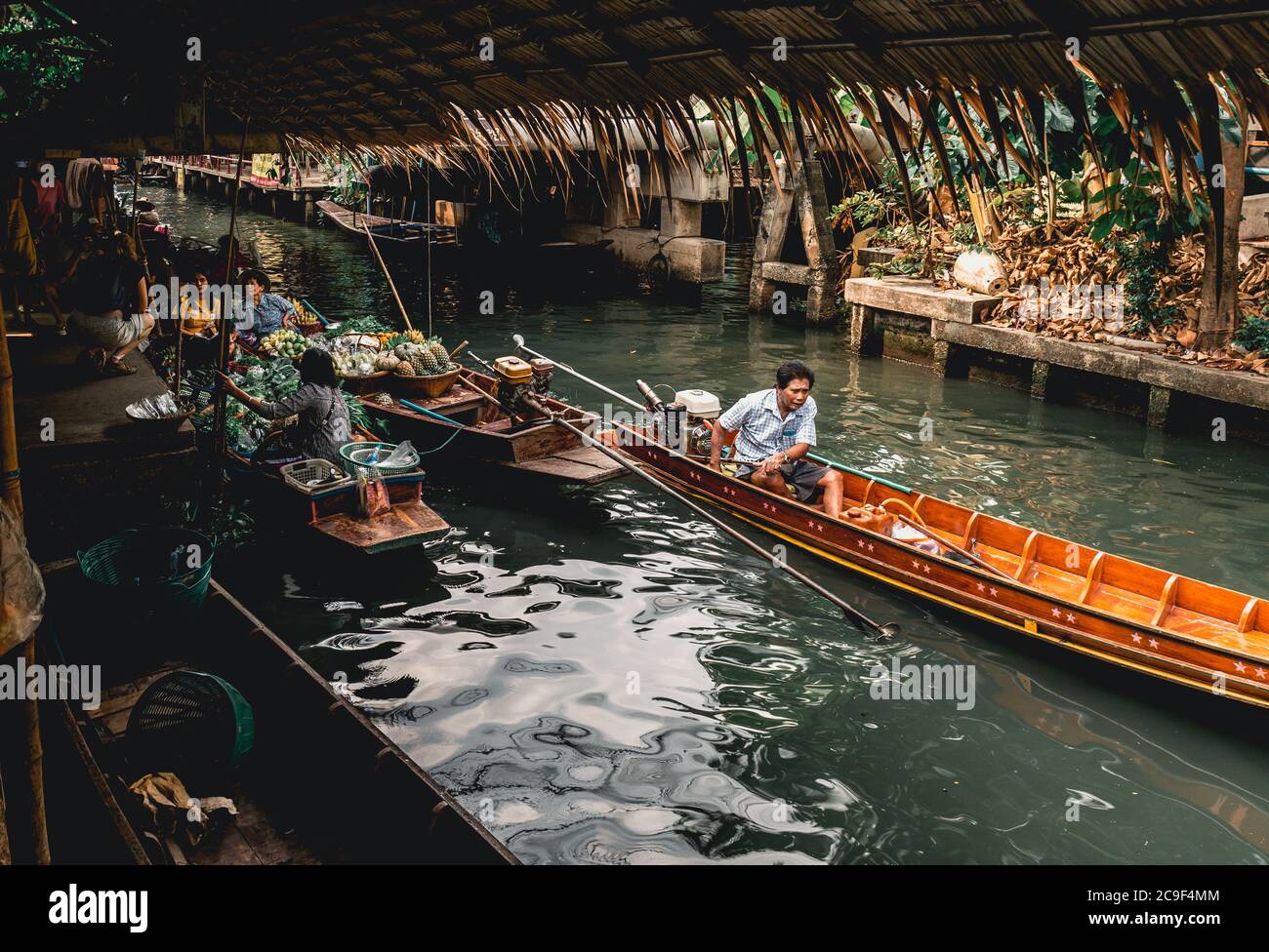 Thailändische Männer in einem Boot auf Taling Chan Floating Market in der Nähe von Bangkok, Thailand. Stockfoto