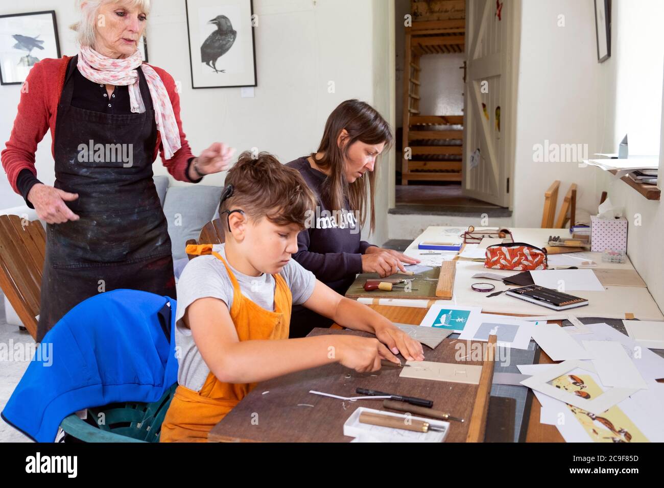 Junge mit Mutter lernen und Frau Künstlerin Lehre Linocutting und Druckgrafik in einem Kunst-Workshop-Klasse in Carmarthenshire Wales UK KATHY DEWITT Stockfoto