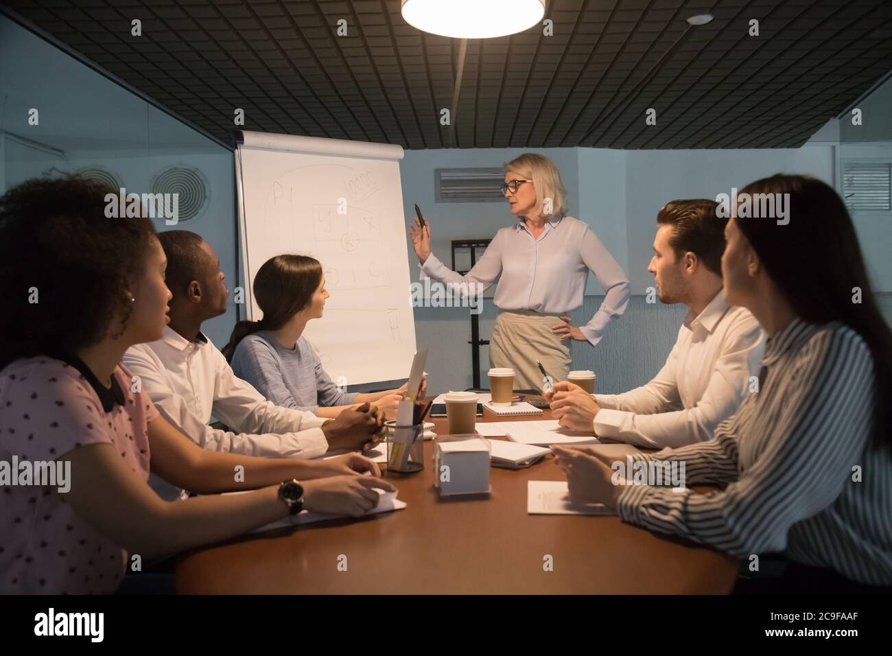 Reife Geschäftsfrau hält Briefing und macht Flipchart-Präsentation Stockfoto