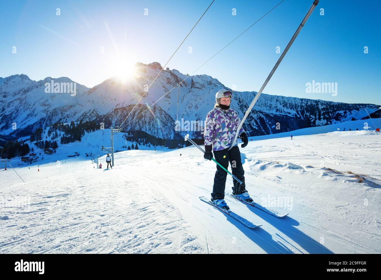 Happy teen Mädchen Heben auf dem Ski Drag Lift Seil in hellen Sport-Outfit  über Sonnenuntergang Licht in der Nähe Berggipfel Stockfotografie - Alamy