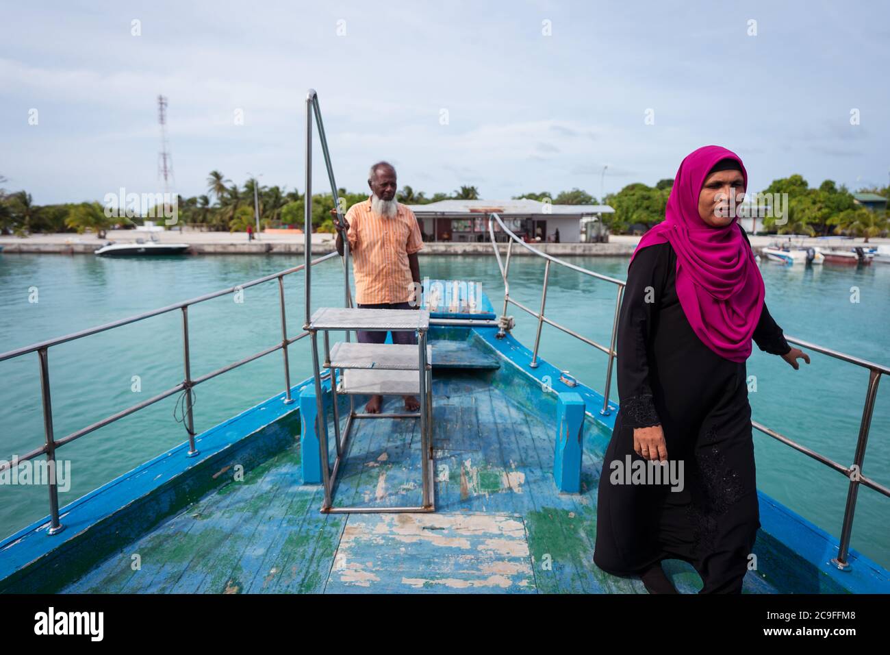 Bodufolhudhoo / Malediven - 17. August 2019: muslimische Frau mit purpurem Hijab und Mann auf dem Fährendeck zwischen den Inseln des Rasdhoo Atolls Stockfoto