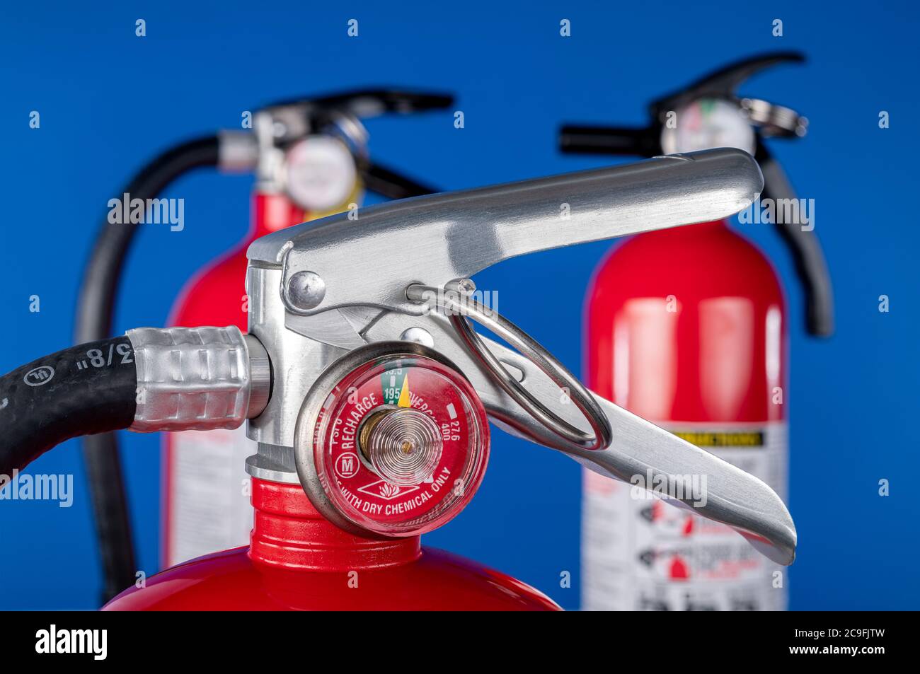 Ein klassisches rotes Feuerlöscherventil auf blauem Hintergrund für den Einsatz als Designelement oder Sicherheitselement für den Schutz von Haus und Betrieb. Stockfoto