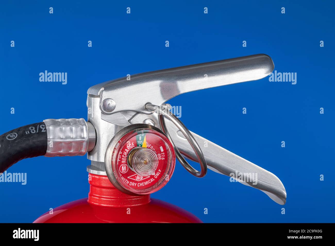 Ein klassisches rotes Feuerlöscherventil auf blauem Hintergrund für den Einsatz als Designelement oder Sicherheitselement für den Schutz von Haus und Betrieb. Stockfoto