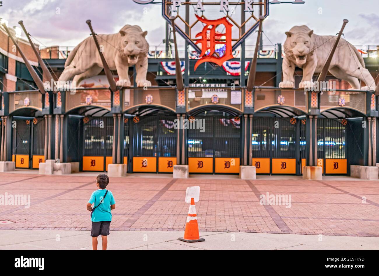 Detroit, Michigan, USA. Juli 2020. Ein Junge steht vor dem Eingang zum Comerica Park während eines Baseballspiels zwischen den Detroit Tigers und den Kansas City Royals. Zuschauern ist es aufgrund der Coronavirus-Pandemie untersagt, das Stadion zu betreten. Kredit: Jim West/Alamy Live Nachrichten Stockfoto