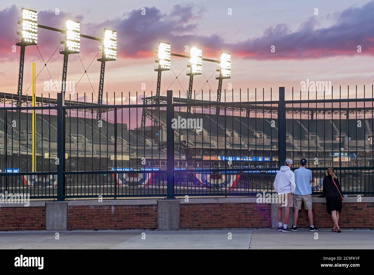 Detroit, Michigan, USA. Juli 2020. Baseball-Fans beobachten die Detroit Tigers spielen die Kansas City Royals durch einen Zaun im Comerica Park. Zuschauern ist es aufgrund der Coronavirus-Pandemie untersagt, das Stadion zu betreten. Kredit: Jim West/Alamy Live Nachrichten Stockfoto