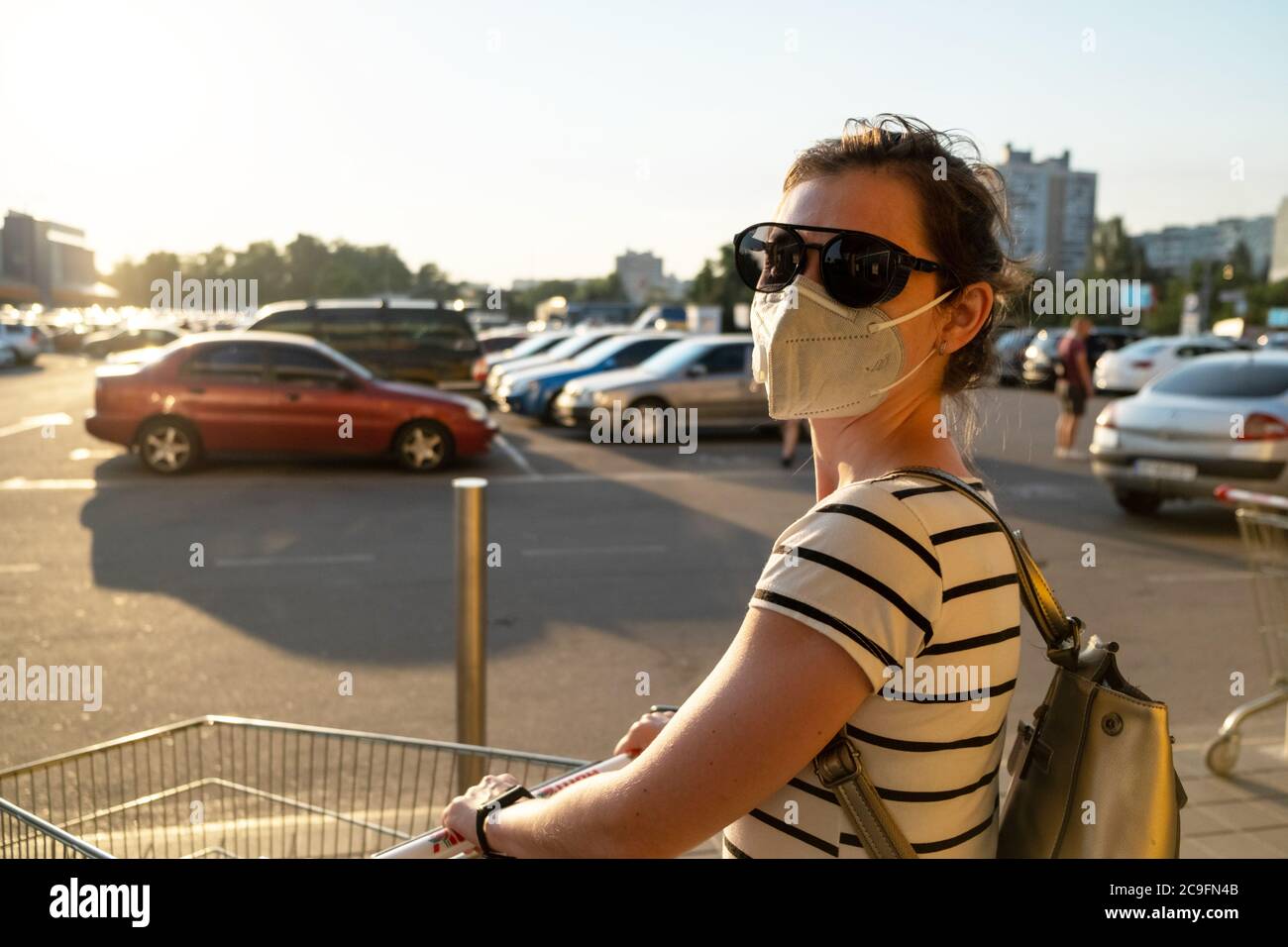 Frau in Maske. Frau aus dem Supermarkt in Schutzmaske bei Coronavirus covid-19 Ausbruch kommen Stockfoto