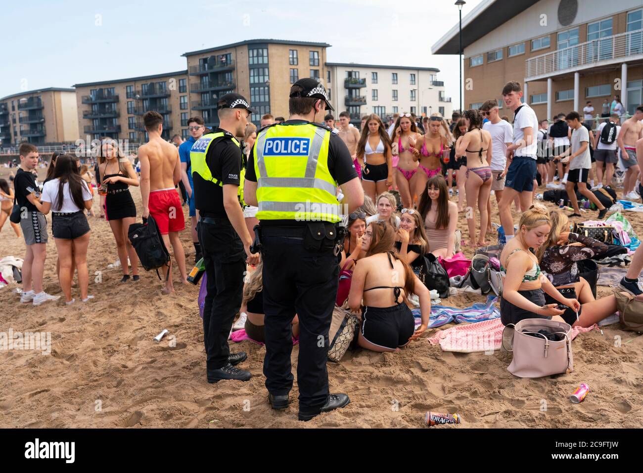 Edinburgh, Schottland, Großbritannien. 31. Juli 2020. Temperatur von 25C und Sonnenschein brachten riesige Menschenmassen nach Portobello Beach außerhalb von Edinburgh. Mehrere große Gruppen von Teenagern genossen den Strand und alkoholische Getränke waren sehr beliebt. Um ca. 15 Uhr brach ein Ärger zwischen jungen Leuten am Strand aus und Polizeiverstärkungen waren schnell vor Ort und mehrere Leute wurden festgenommen. Westbank Street war für den Verkehr gesperrt und ca. 30 Polizisten patrouillieren die Promenade. Die Polizei beschlagnahmt Alkohol von den Teenagern, die am Strand bleiben. Iain Masterton/Alamy Live News Stockfoto