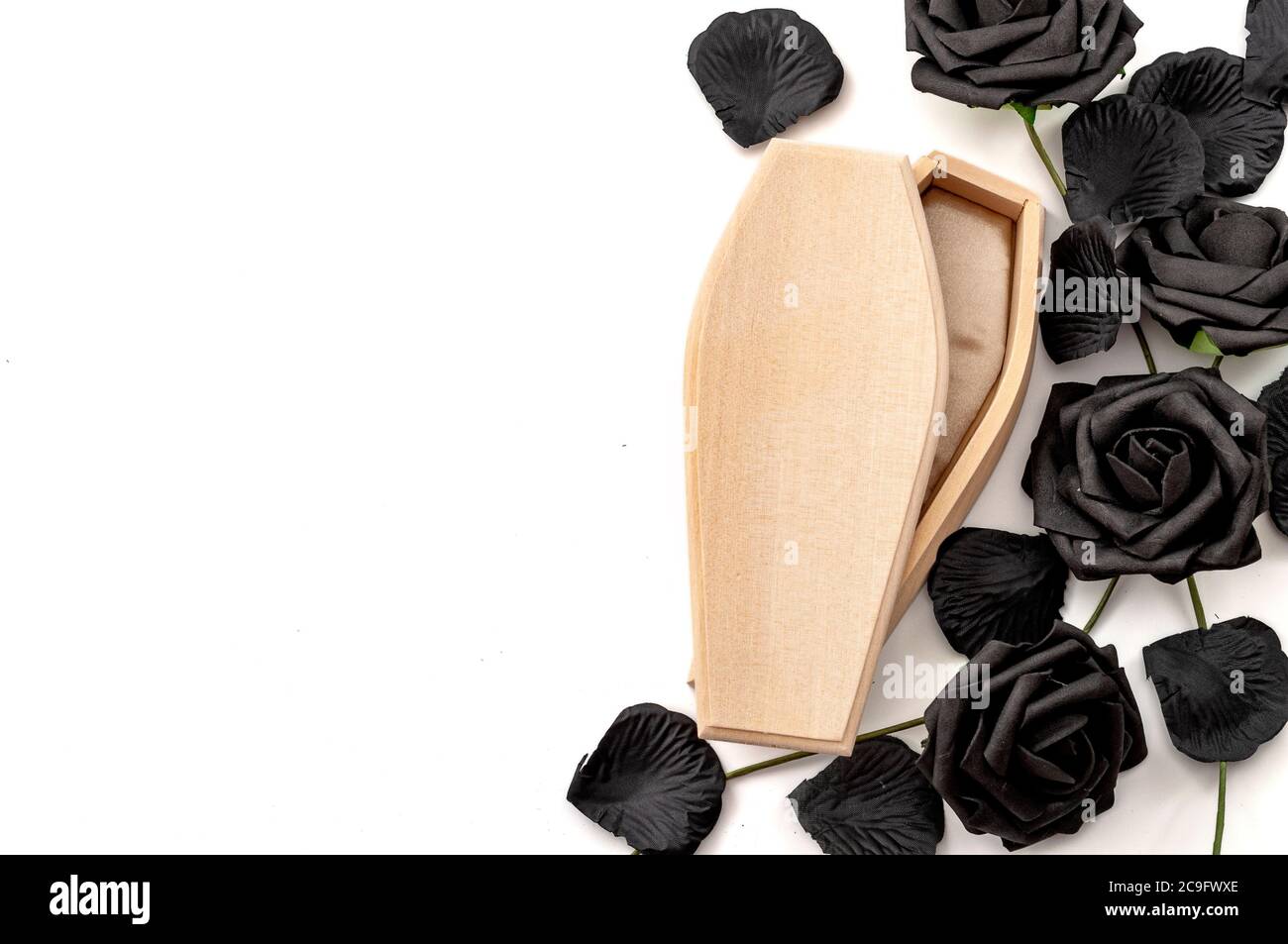 Last Auf Wiedersehen, Trauer um die Verstorbenen und Traurigkeit des Verlierens Lieben Konzept mit Holzsarg umgeben von schwarzen Rosen isoliert auf weißem Hintergrund Stockfoto