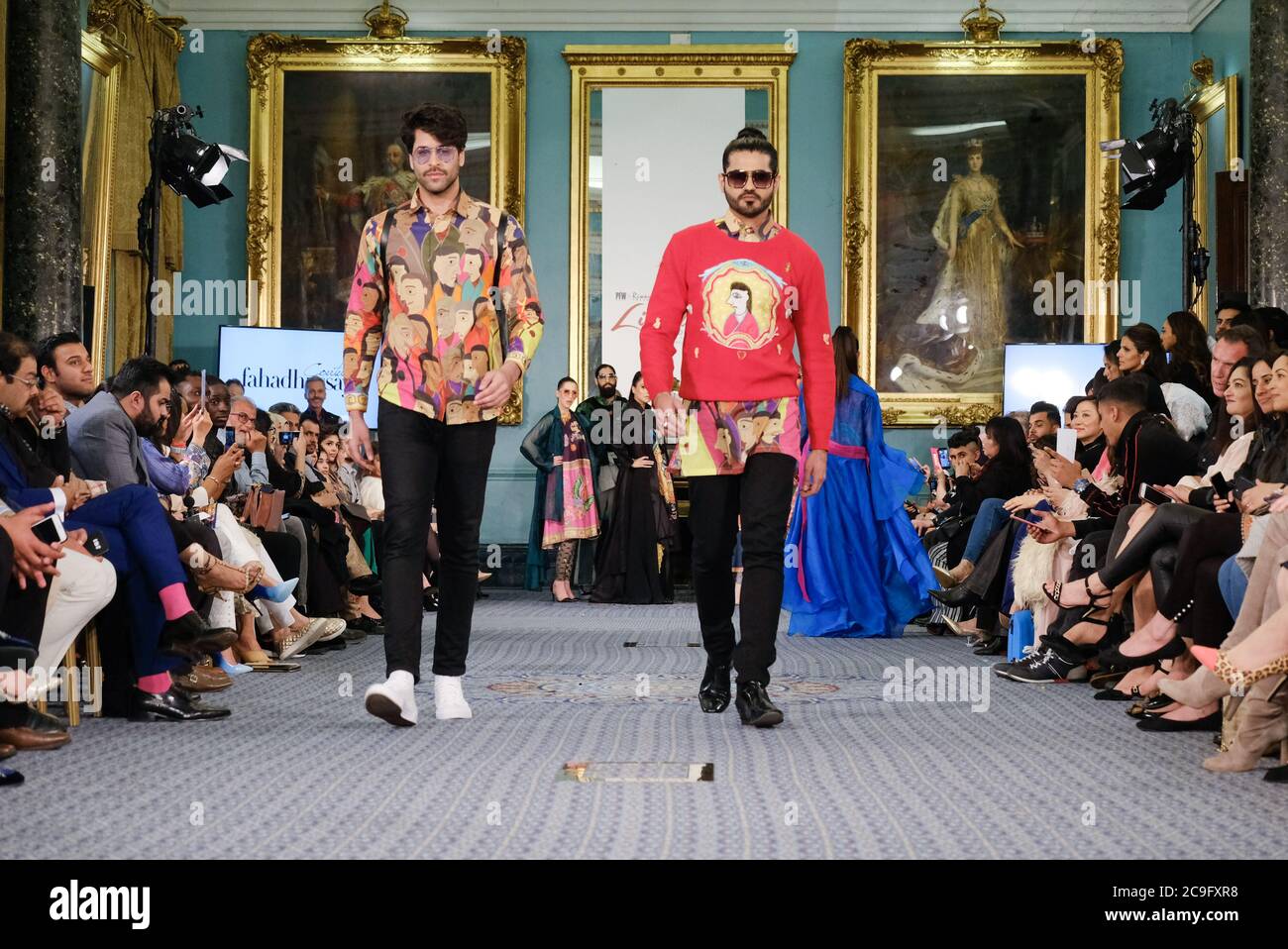 Zwei asiatische männliche Models laufen für Designer Fahad Husseyn während des Lifestyle London Fashion Events. Stockfoto