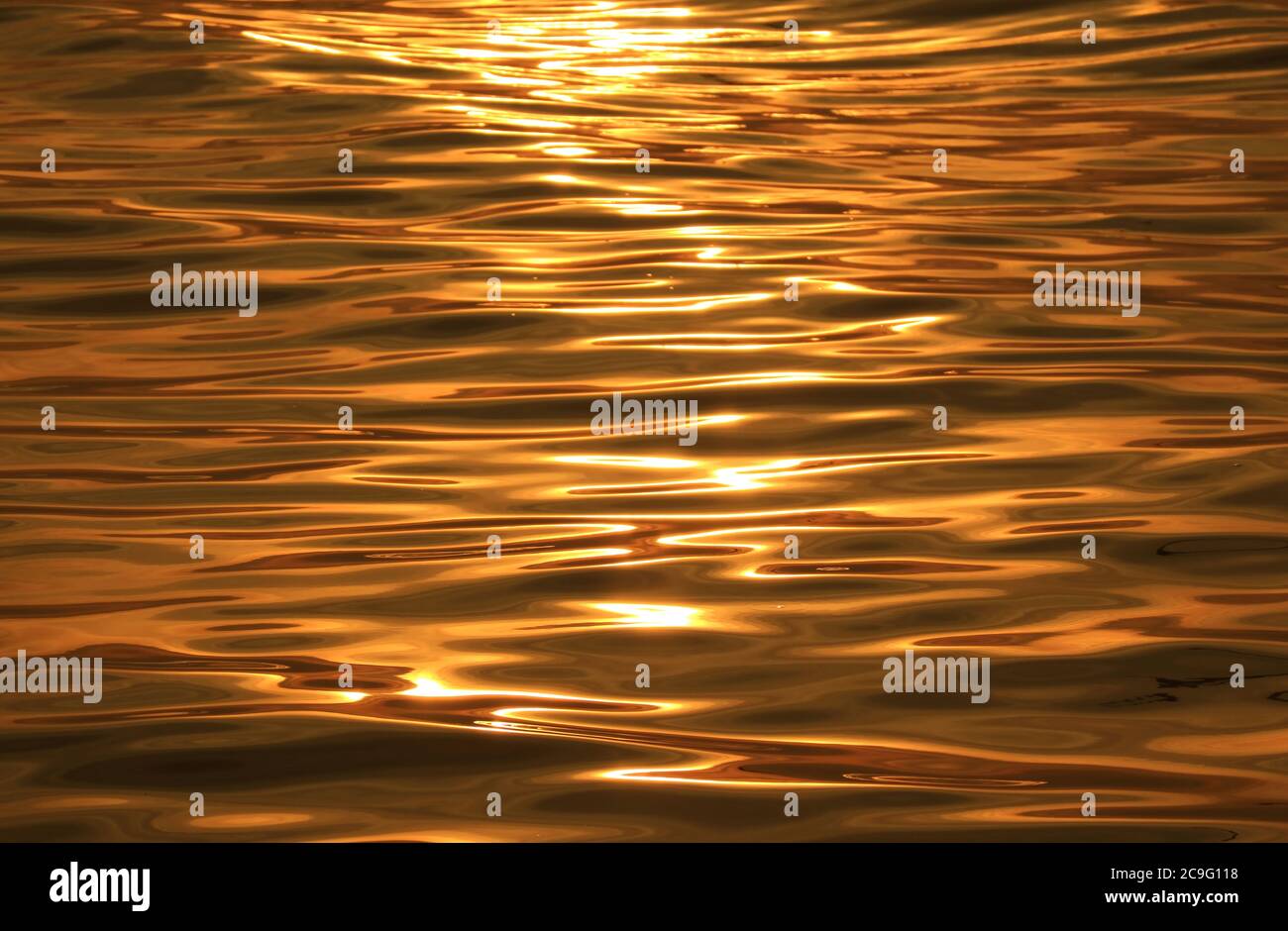 Abstrakter Hintergrund der goldenen Wasseroberfläche mit Sonnenreflexionen Stockfoto