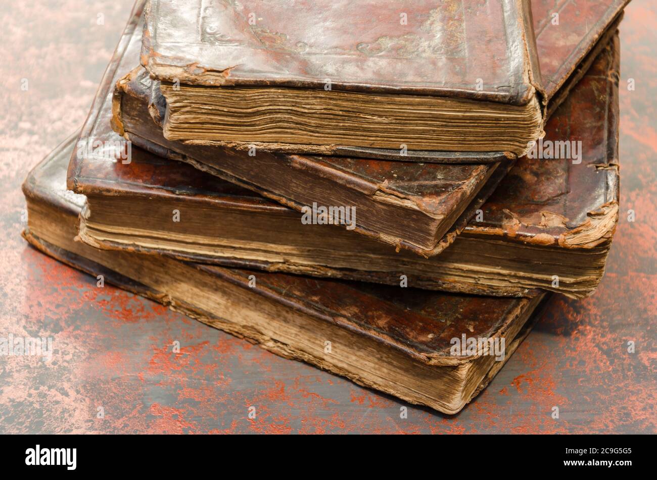 Stapel alter und abgenutzter Ledereinband-Bücher mit Blattgold-Prägung. Nahaufnahme Stockfoto