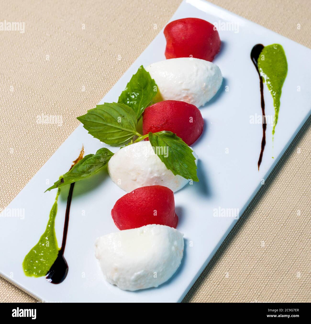 Schöne Eiskugeln mit Tomate auf dem weißen Teller Stockfoto