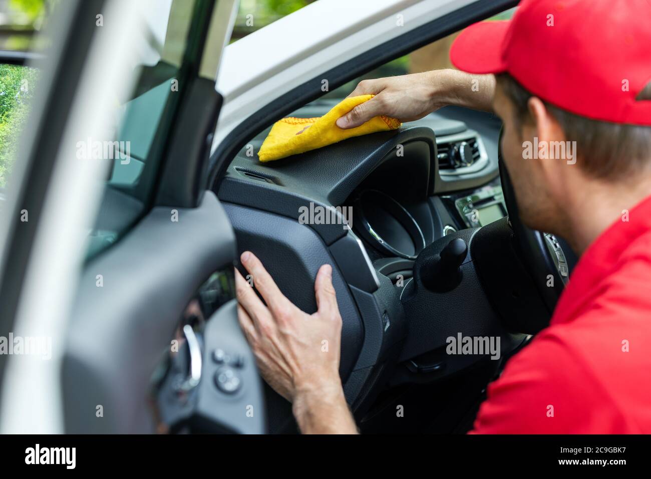 Autowascharbeiter Reinigung Auto Innenraum mit Mikrofaser Tuch Stockfoto