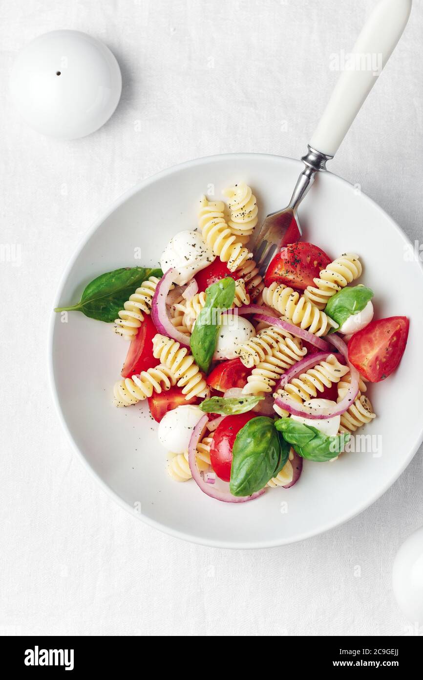 Caprese Nudelsalat mit Tomaten, Mozzarella-Käse, Basilikum. Stockfoto