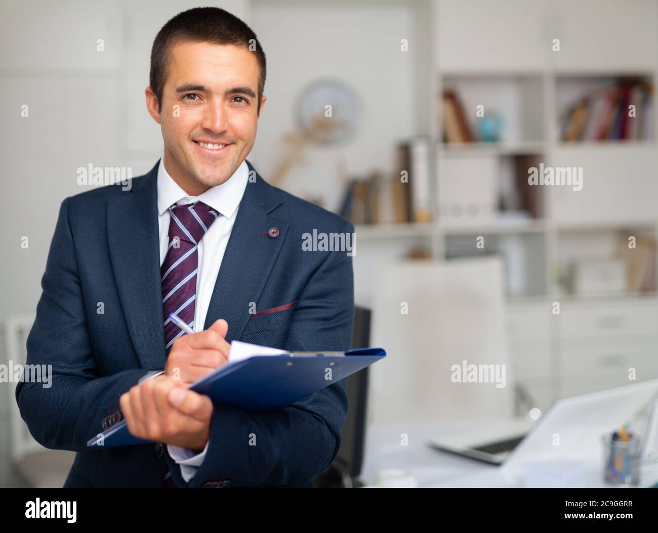 Portrait von positiven Geschäftsmann mit Ordner von Dokumenten im Büro Stockfoto