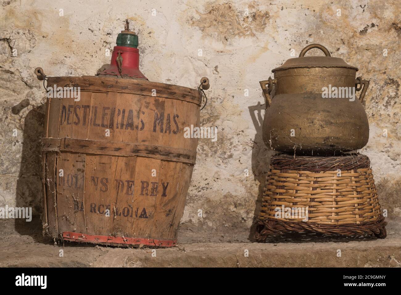 Antike Ballonflasche spanischer Demijohn und Stewpot an der Lagerung eines alten Hauses aufgegeben, mit Spinnweben und Wand mit Feuchtigkeit Stockfoto