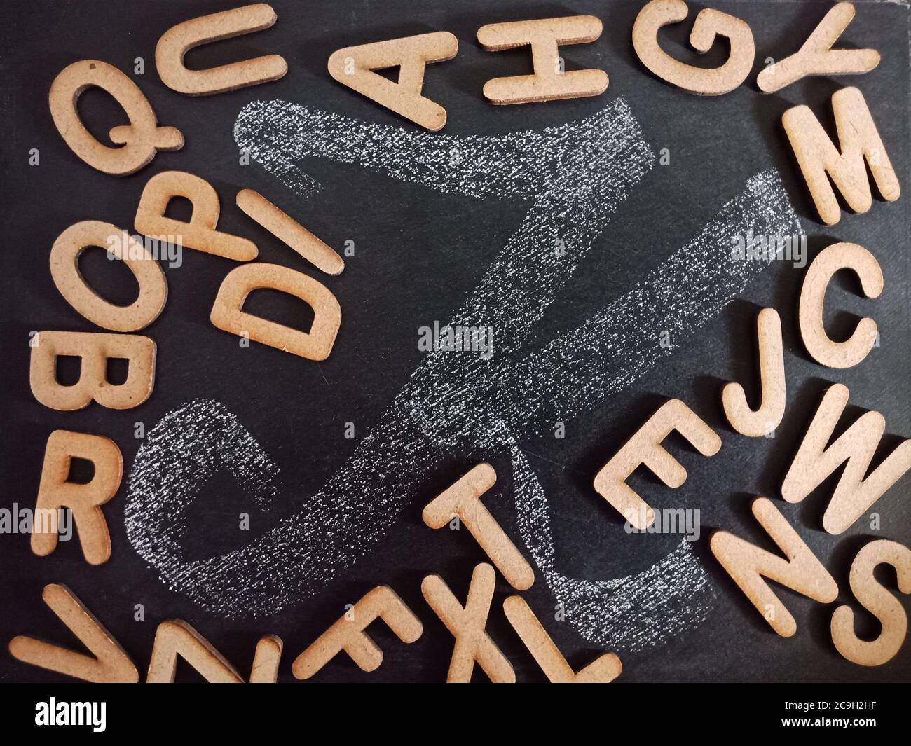 Englisches Alphabet Buchstabe K Anzeige mit allen alphabetischen Text Sammlung auf schwarzem Brett Oberfläche Hand geschrieben und Holz gemischten Hintergrund. Stockfoto