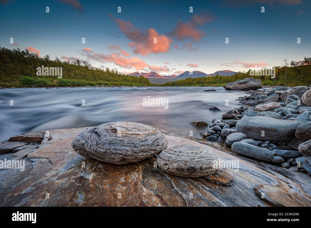 Zwei runde Steine liegen am Flussufer im Abendlicht, Abisko Nationalpark, Lappland, Bjoerkliden, Norrbottens laen, Schweden Stockfoto